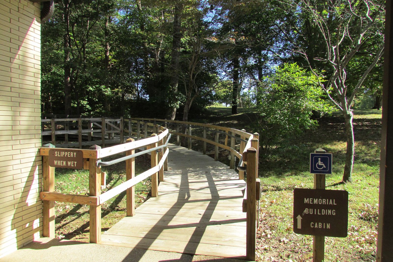 A level accessible boardwalk through forest with a wheelchair-symbol trail sign
